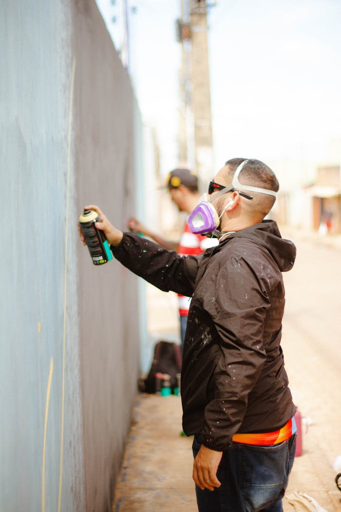 Men in Masks Drawing Graffiti on Wall